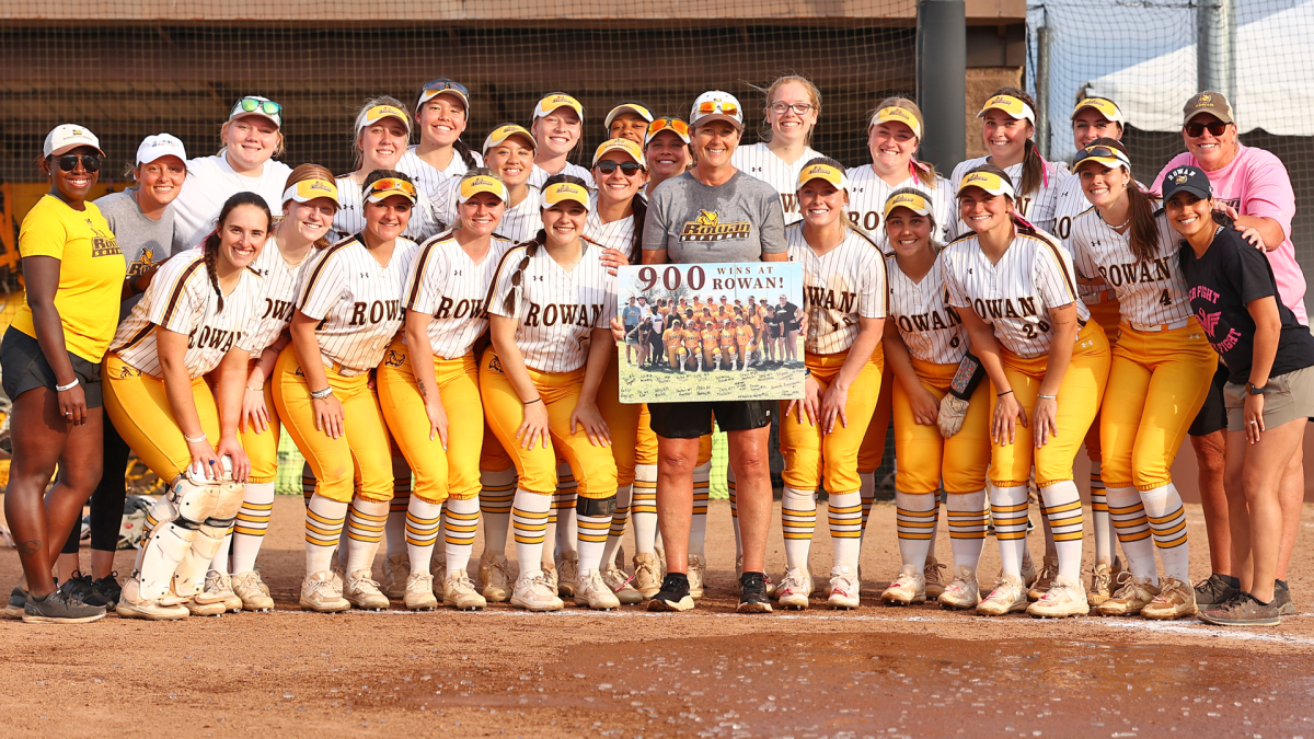 Kim Wilson and the team celebrates her 900th win at Rowan. Wilson recorded her 900th win on Tuesday. - Photo via Rowan Athletics