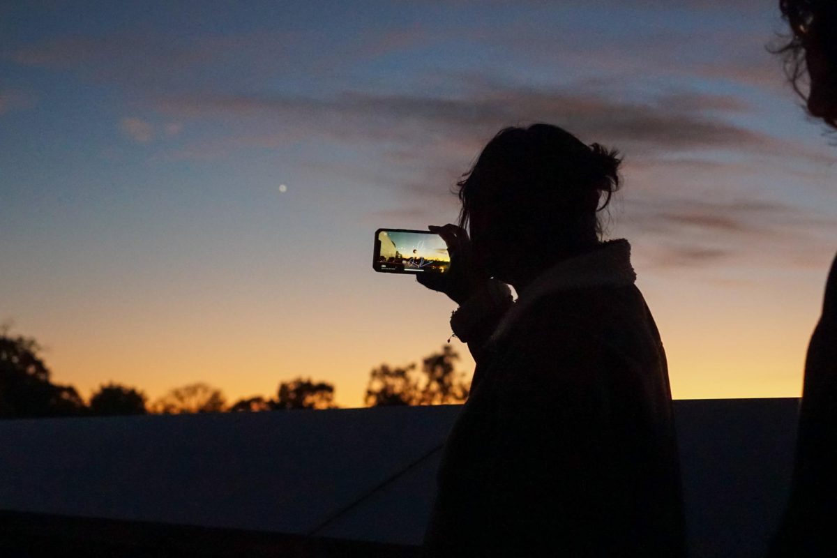 An onlooker uses a skywatching app on their phone, looking towards Venus at dusk. - Photography Editor / Gavin Schweiger