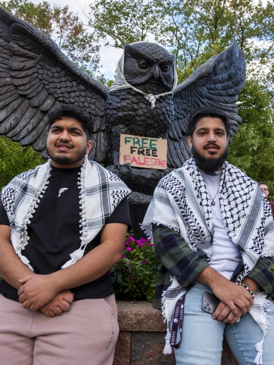 Two students at the protest stand in front of the owl statue. - Multimedia Editor / Matthew Millroy