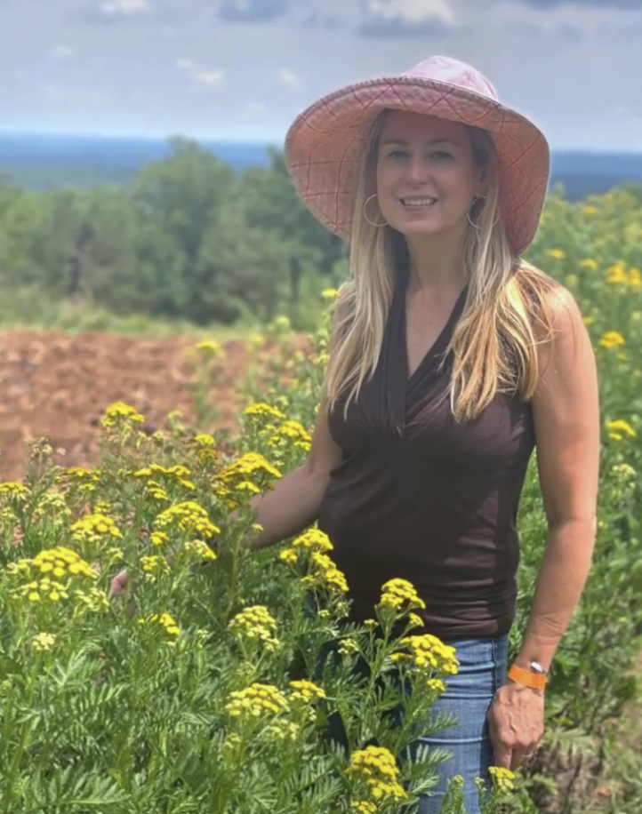 Toni Farmer, adjunct professor at Rowan University and creator of Toni Farmer's Garden standing by some flowers. - Photo / Jamie Farmer. 