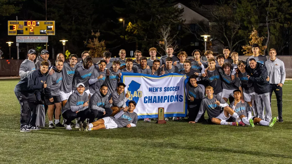 The team poses for a photo with the NJAC Championship trophy and banner. - Photo via Rowan Athletics