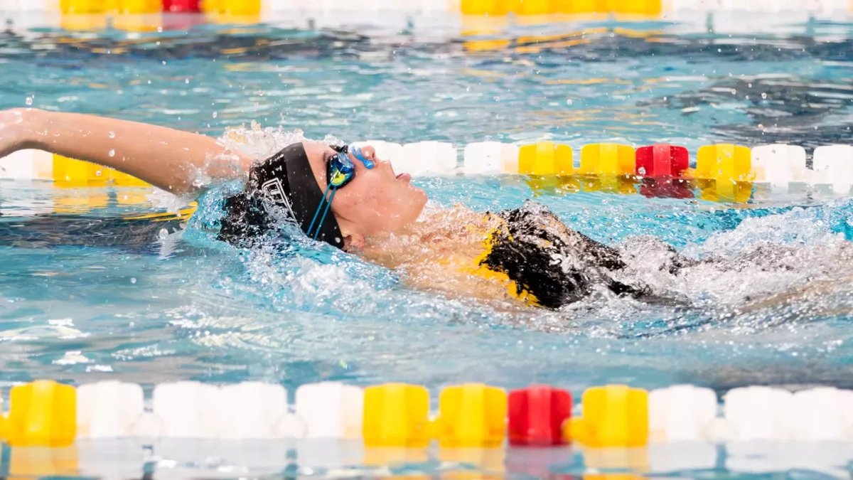 Ella Pennington competes in the backstroke. Pennington won three events. - Photo via Rowan Athletics