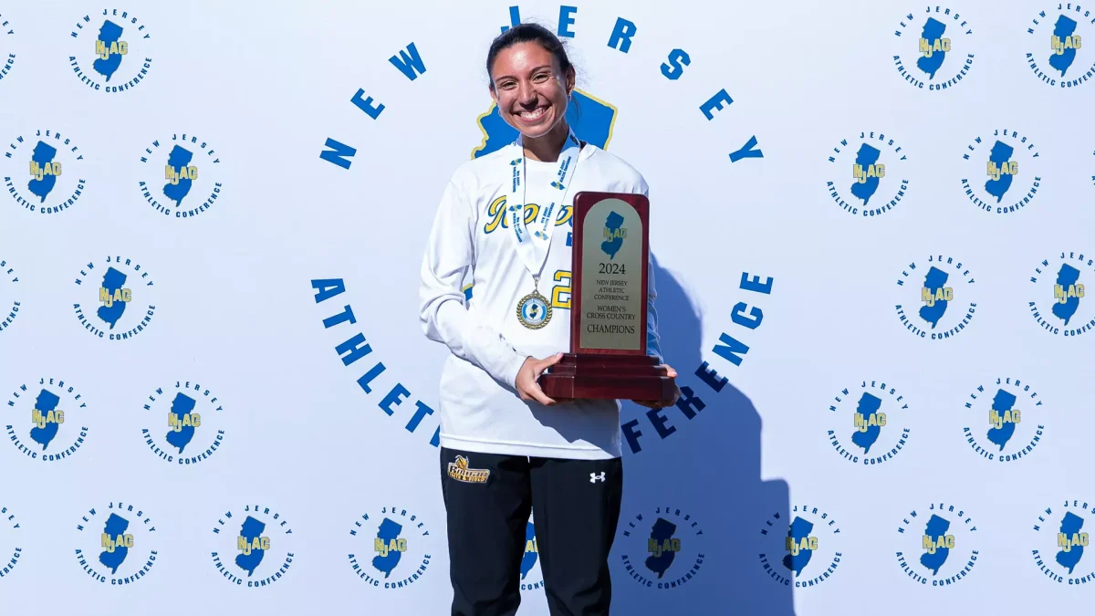 Senior Mia Guerra, who placed first at the NJAC Championships, poses with Rowan's first place trophy. - Photo via Rowan Athletics