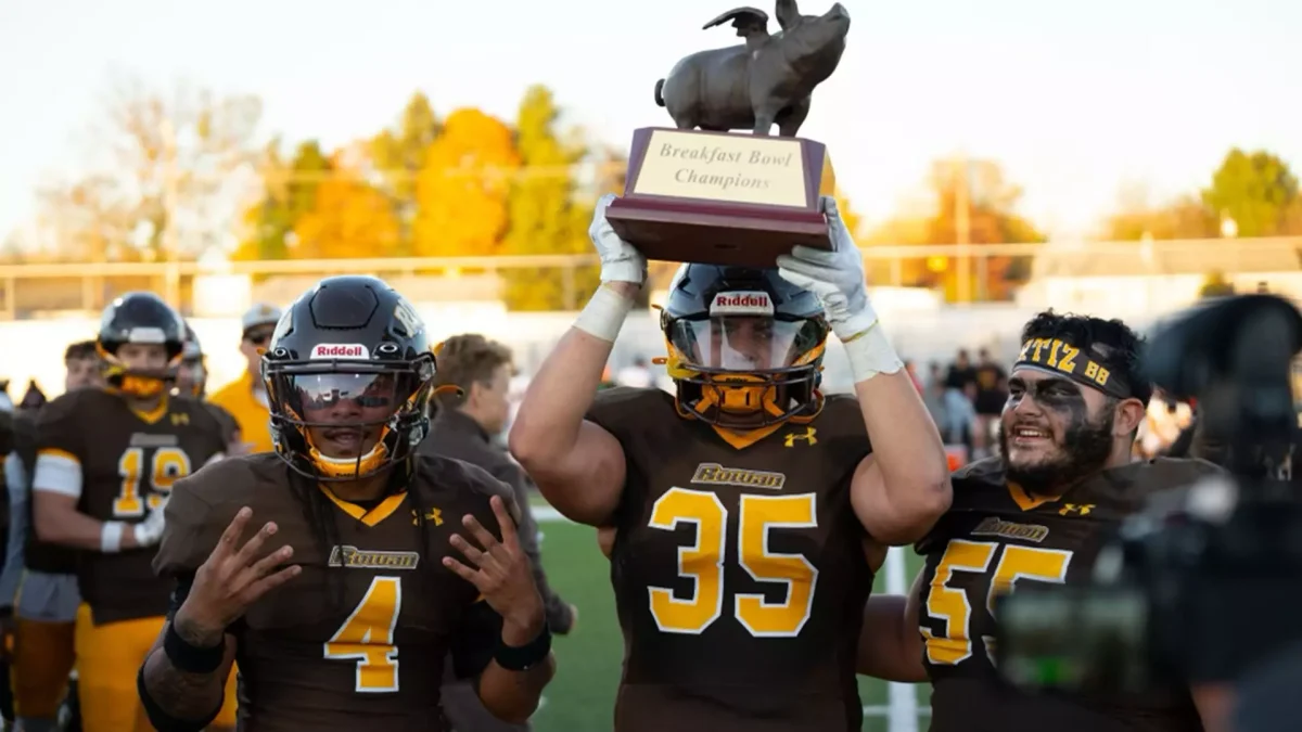 The Profs celebrate with the Breakfast Bowl trophy following their win against Montclair State. - Photo via Rowan Athletics