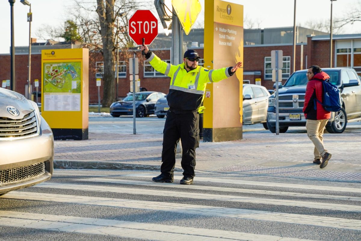 Crossing guard Vincent Bristow stops traffic for student crossing Route 322. - Photography Editor / Gavin Schweiger