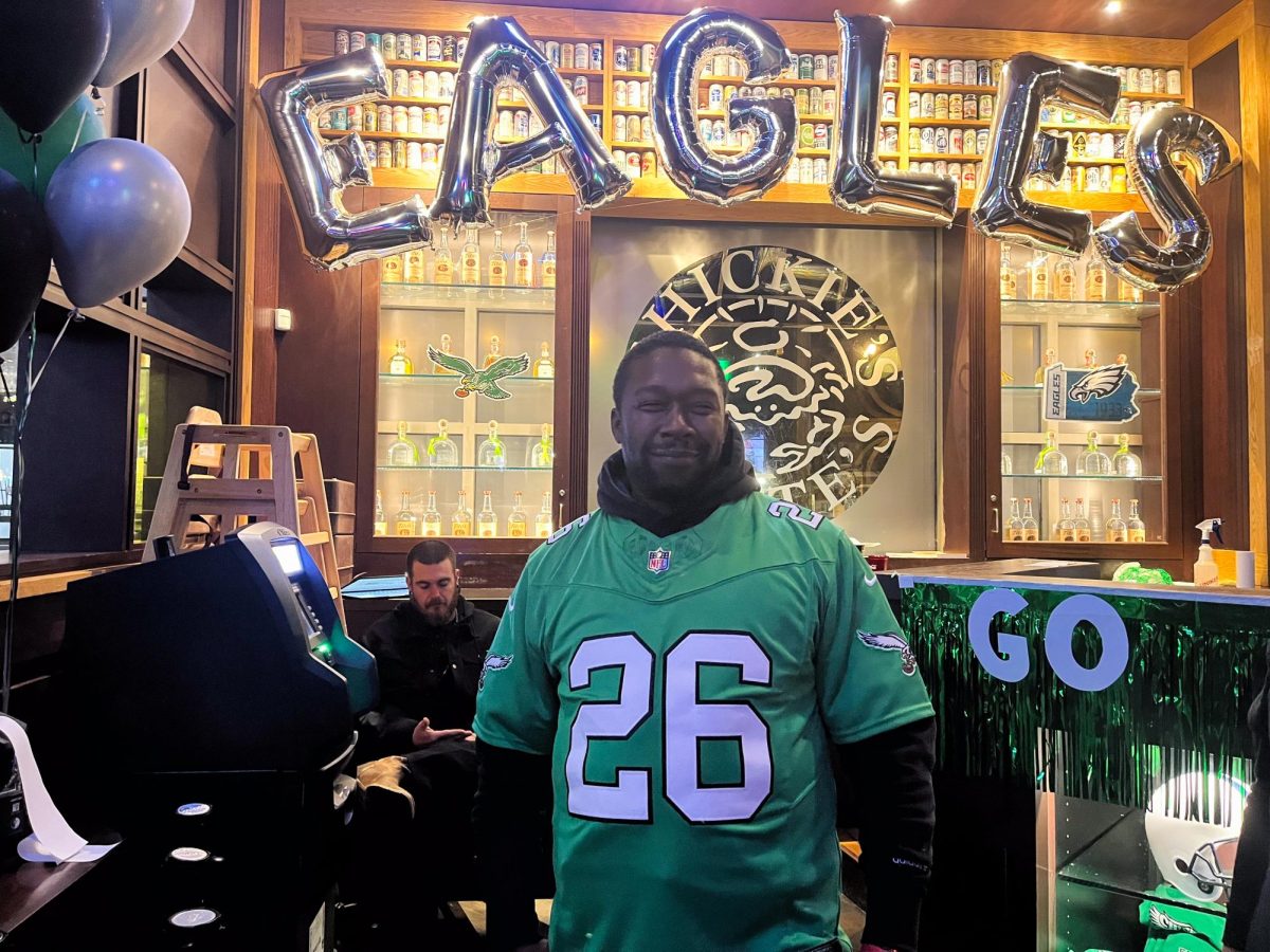 Chickie's and Pete's kitchen manager and Cowboys’ fan, Tysean Allen, poses for a photo in an Eagles’ jersey after losing a bet that the Eagles would lose the Super Bowl. Glassboro, NJ. Sunday, Feb. 09, 2025. - Staff Writer / Rachel Sampson