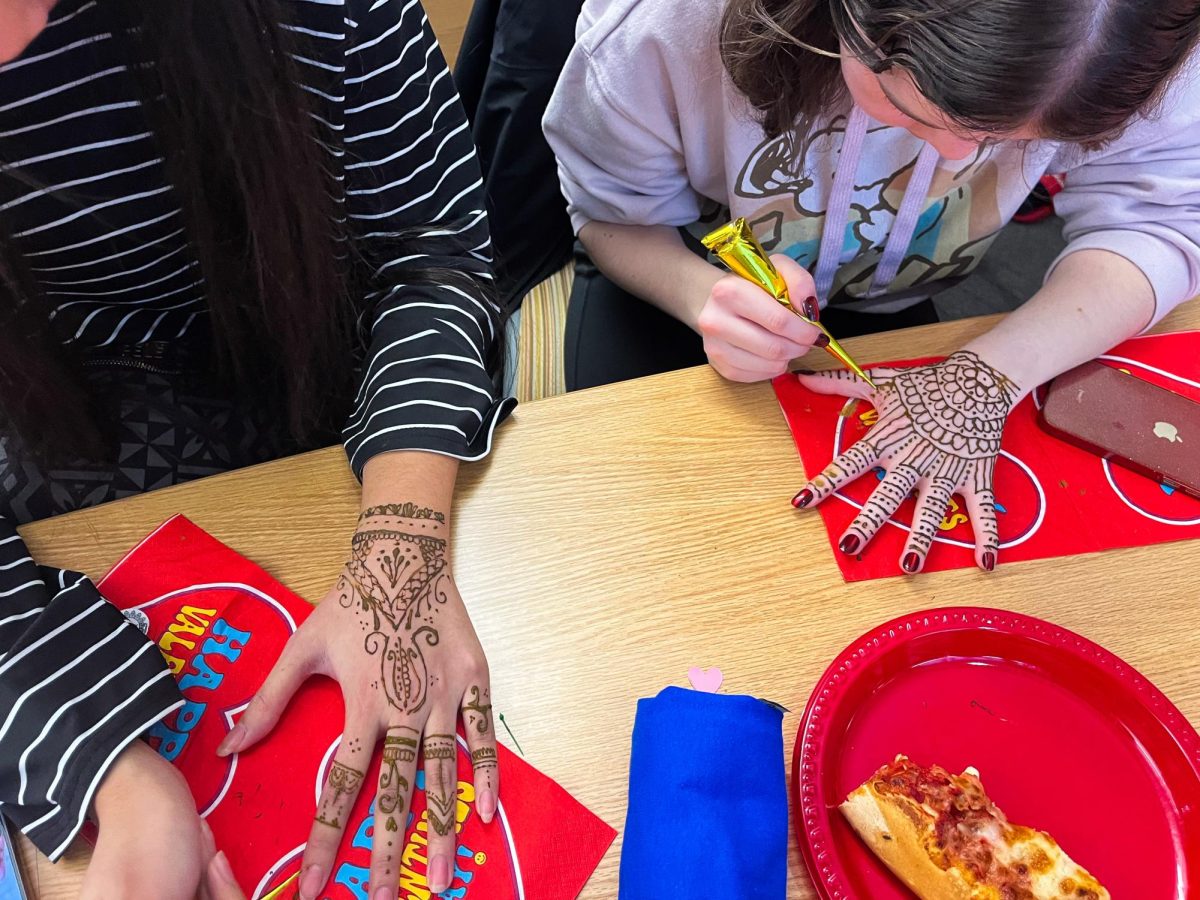 Participating members paint henna on their hands. - Staff Writer / Julissa Sierra