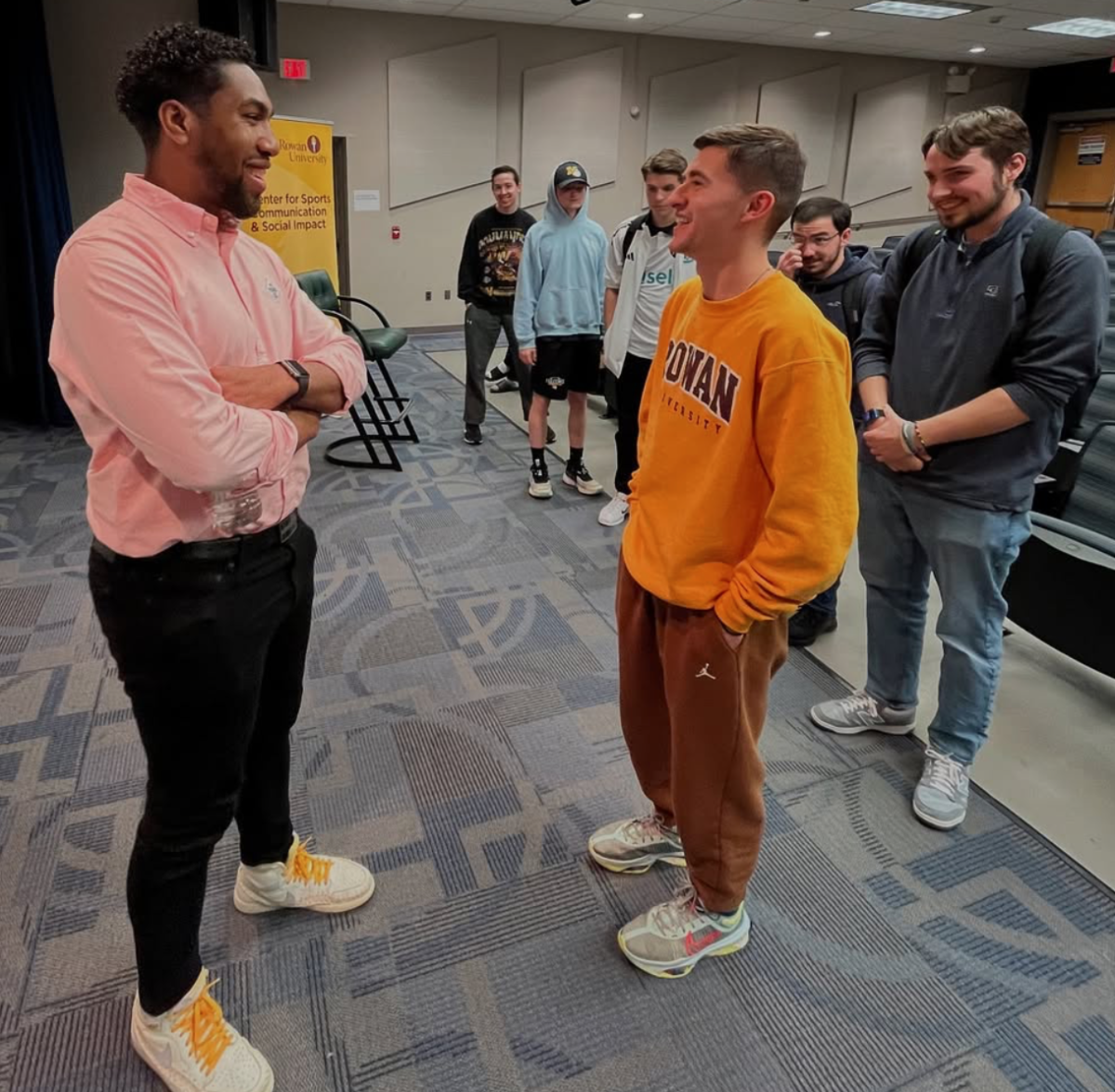 Chris Lewis talking to students at Pizza with the Pros. - Photo via @rowansportscam on Instagram. 