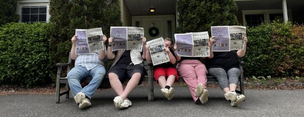 The D'Aquila family sits on a bench and holds copies of South Jersey Local. - Photo via the D'Aquila family