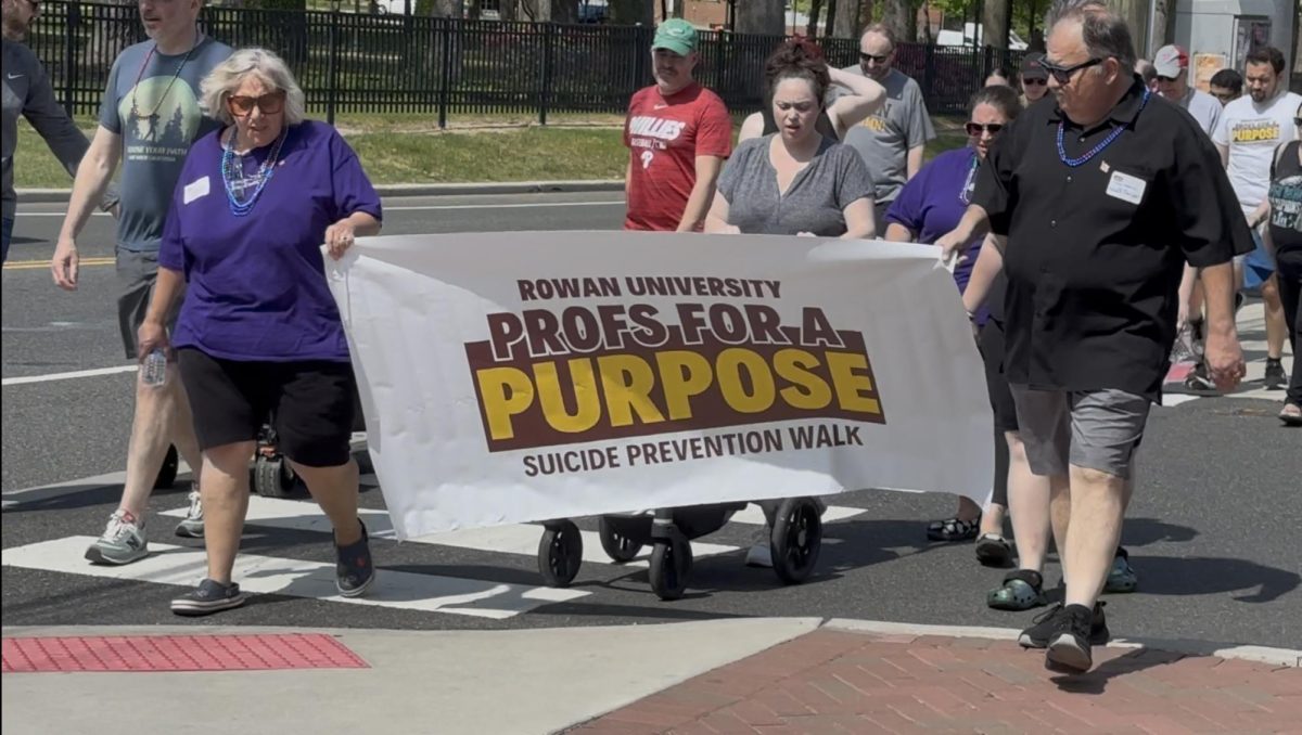 Volunteers carry banner for the Profs For A Purpose: Suicide Prevention Walk, Rowan University, May 3. 2025.  – Staff Writer / Hayden Fugee
