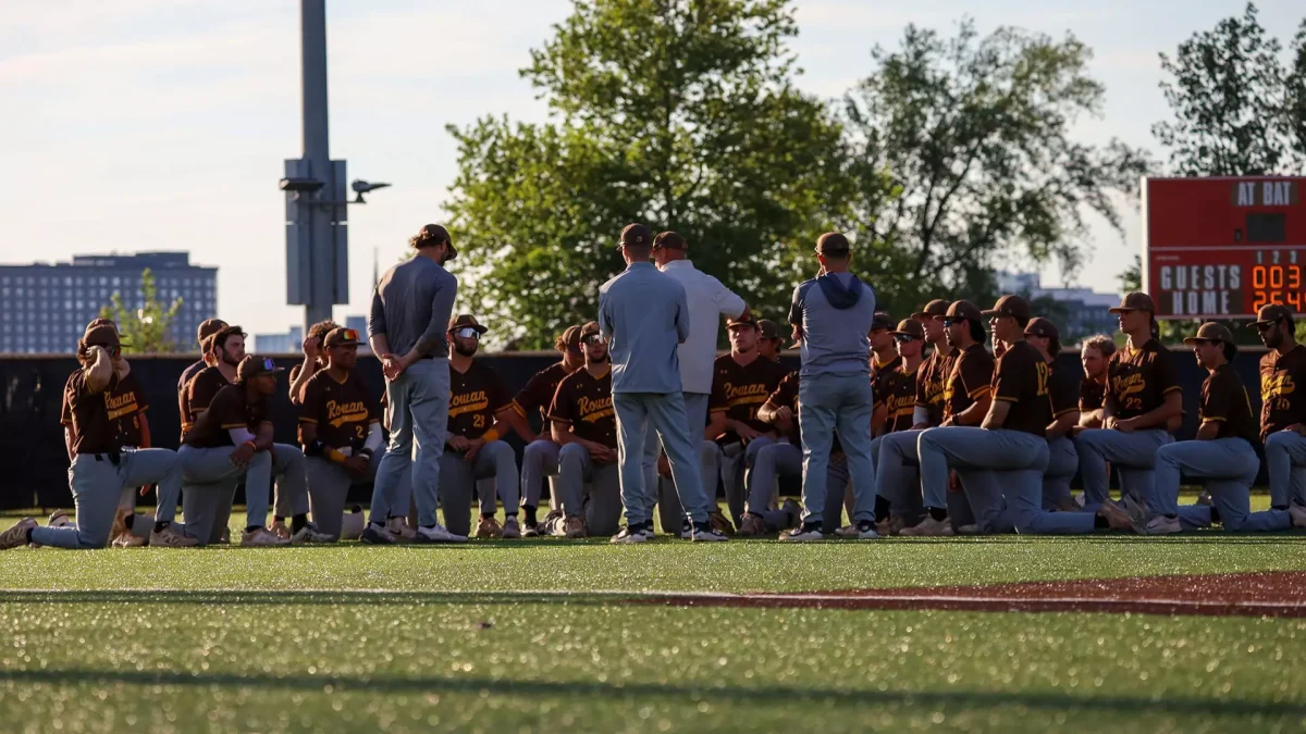 Rowan baseball huddles up in left field for their post-game meeting. The Profs suffered their first loss of the double-elimination tournament against Rutgers-Camden. - Photo via Joe Casano
