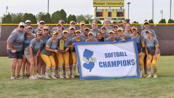 The Rowan softball team poses with their NJAC Champions banner. The program has won back-to-back conference titles for the first time since the 2001-02 seasons. Glassboro, NJ. Sunday, May 11, 2025. - Photo via Rowan Athletics