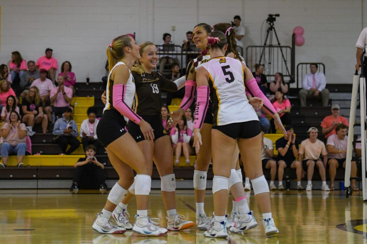 The women's volleyball team celebrates after scoring a point during a set. (Contributor / Trevor Miceli)