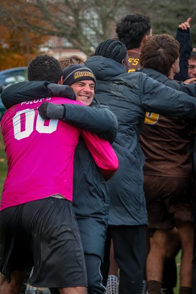 Head coach Scott Baker hugs goalkeeper Travis Holiday after advancing to the NCAA Sweet Sixteen. Wesleyan, Conn. Sunday, Nov. 16, 2025. (Sports Photographer / Johan Capellan)