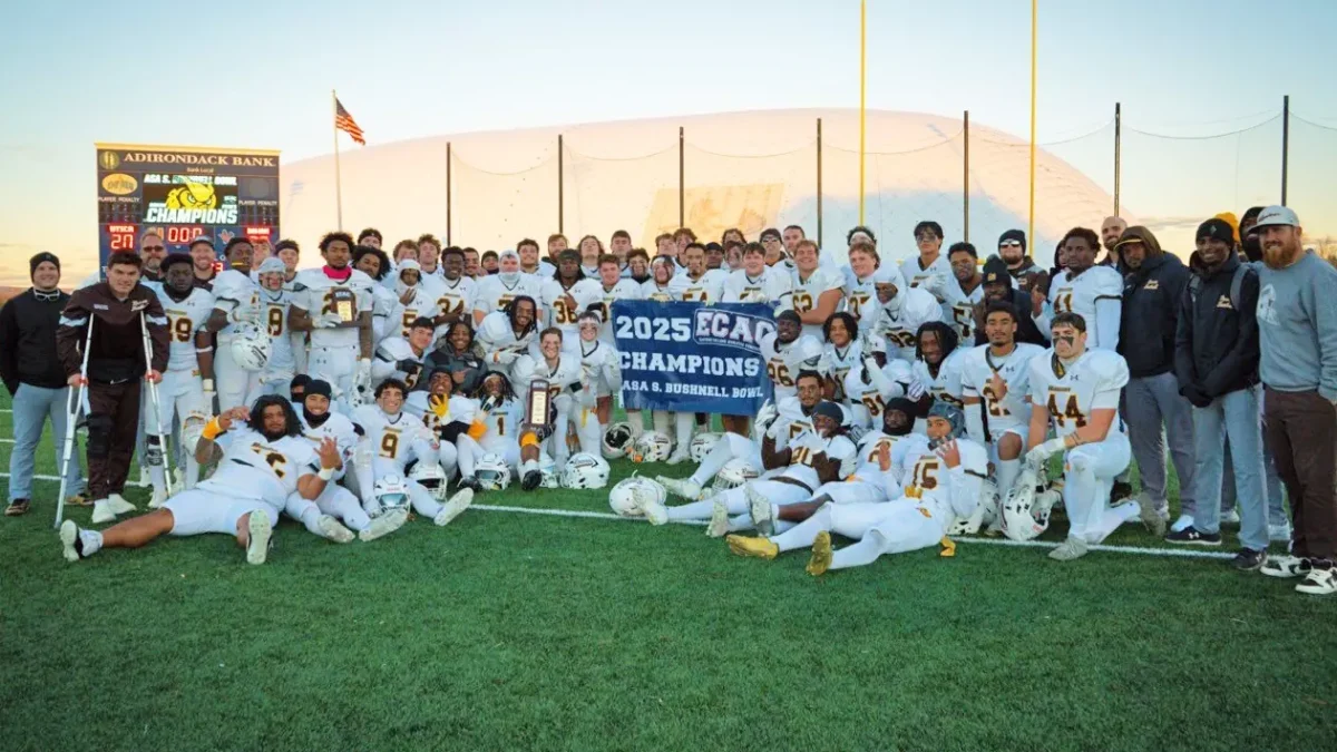 The team poses with their ECAC banner. Utica, N.Y. Saturday, Nov. 22, 2025. (Rowan Athletics)