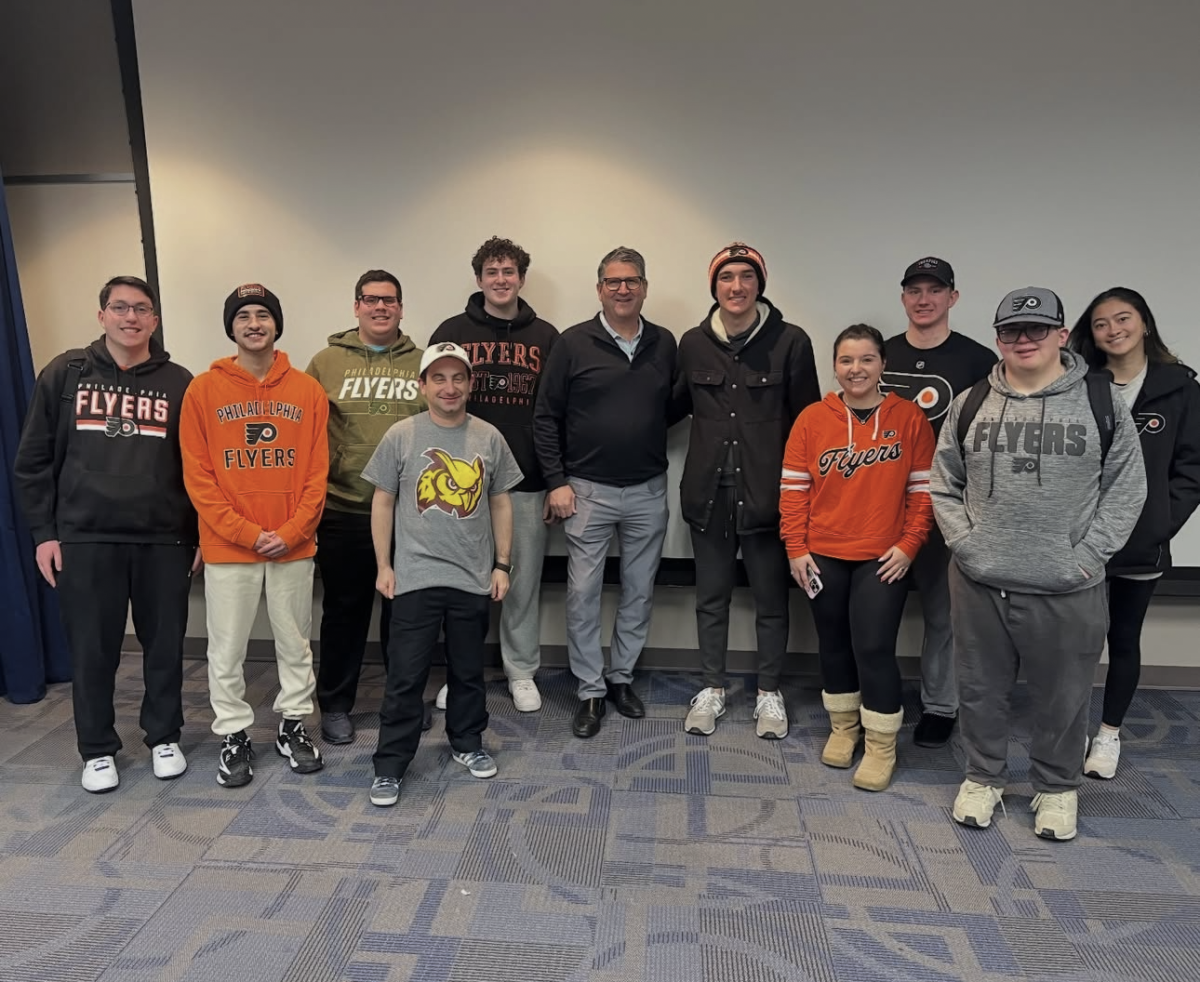 Keith Jones takes a photo with student attendees of Pizza with the Pros wearing their flyers gear. Glassboro, N.J. Monday, Feb. 2, 2026. (@rowansportscam on Instagram)