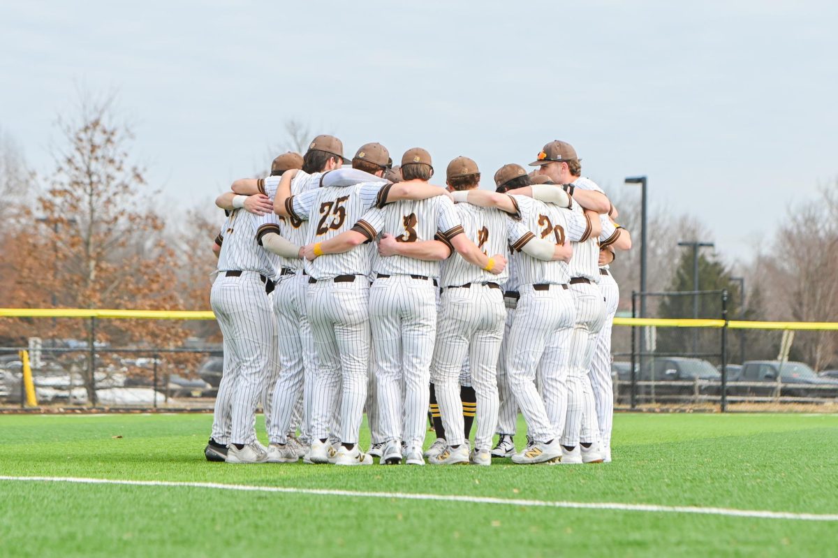 The baseball team huddles up in left field pregame. (Sports Photographer / Trevor Miceli)