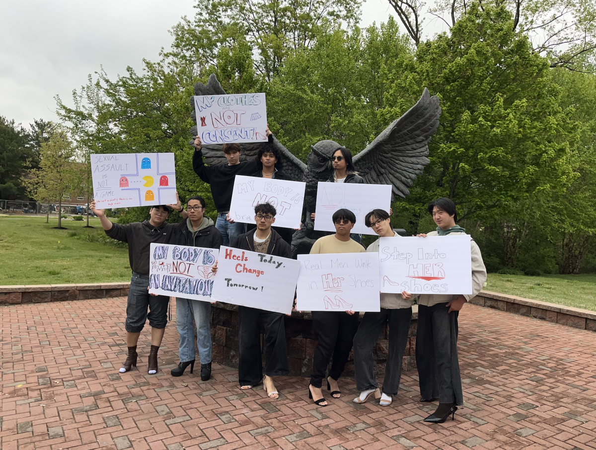 Students stand in front of the Rowan owl statue with their signs. Sunday, April 26, 2026. Glassboro N.J. (Staff Writer / Joseph Weigle)