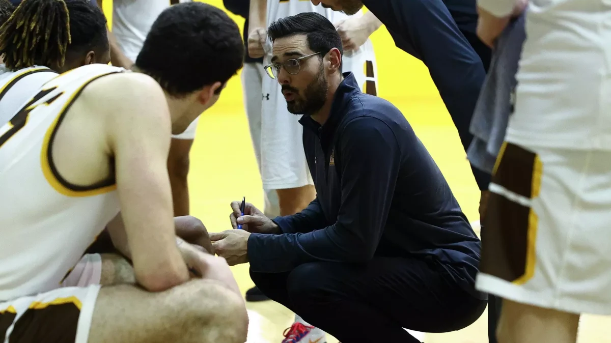 Eric Brennan talks to his team. (Rowan Athletics)